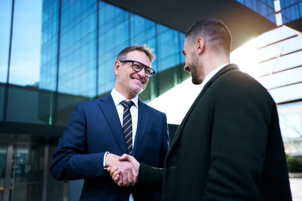 Diverse business team shaking hands outside office after partnering with a UX/UI design agency in Australia.