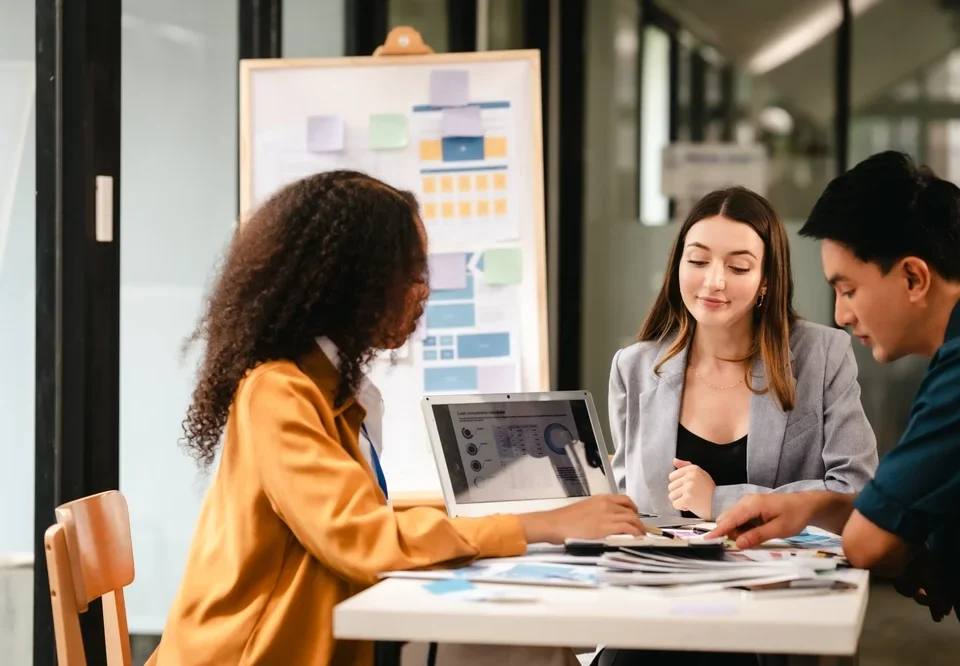 Diverse creative team discussing UX and UI design strategies during a branding and digital marketing meeting.
