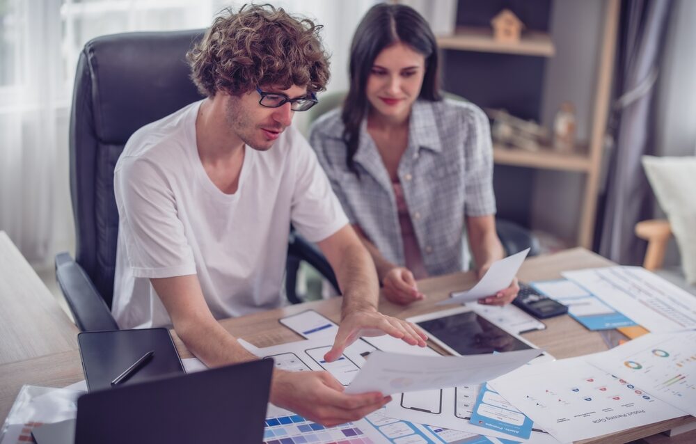 Mobile app developers collaborating on UI/UX design and prototyping for scalable, cross-platform business apps.