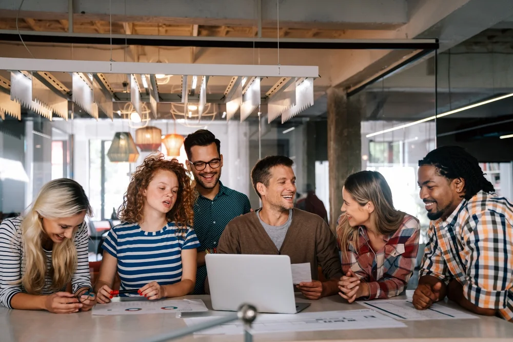 Team of developers smiling and collaborating on a project, symbolizing fast and enjoyable app development process.